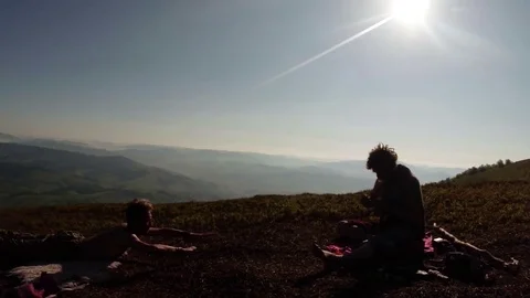 The yogi makes lying postures on the stomach in the mountains under the sun next Stock Footage 77784801