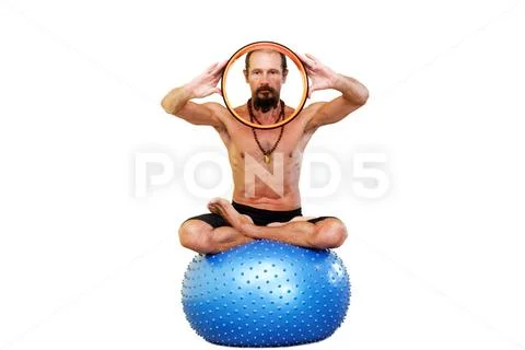 Yogi man practicing yoga with fitness ball. Stock Photos
