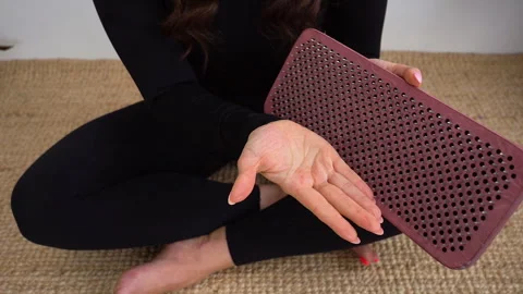 Yogi woman's hand touches a sharp nail on a sadhu board. Alternative medicine. Stock Footage 242196679