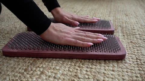Yogi woman's hand touches a sharp nail on a sadhu board. Alternative medicine. Stock Footage 242505272