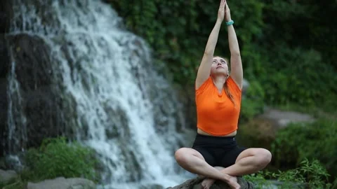 Yogic meditation practice Yogic doing yoga on the rocks against the waterfall Stock Footage 160418200