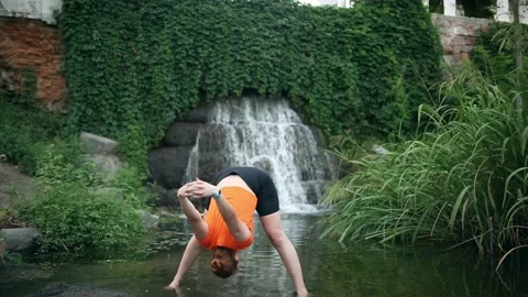 Yogic meditation practice Yogic doing yoga in water against the waterfall Stock Footage 160418345