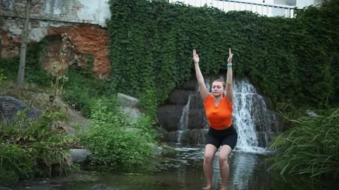 Yogic meditation practice Yogic doing yoga in water against the waterfall Stock Footage 160418385