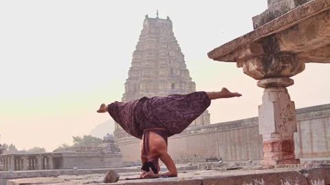 Yogini doing a headstand with a split Stock Footage 264085195