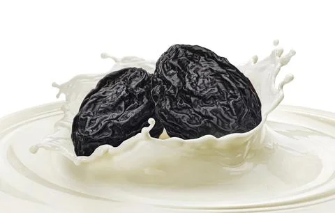 Yogurt with dry plum, prune in milk splash isolated on white background Stock Photos