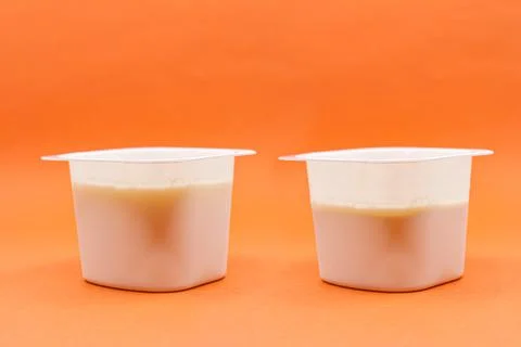 Yogurt less full than the previous one. Shrinkflation concept Stock Photos