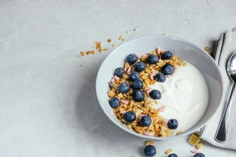 Yogurt with muesli and berries on a gray background. Stock Photos
