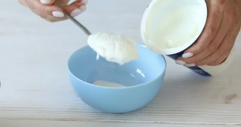 Yogurt or sour cream is placed in a bowl from the package. Stock Footage 249593902