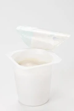 Yogurt in plastic box container over white background Stock Photos
