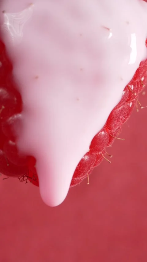 Yogurt is poured onto red ripe raspberry berries, macro. Healthy food concept Stock Footage 308931130
