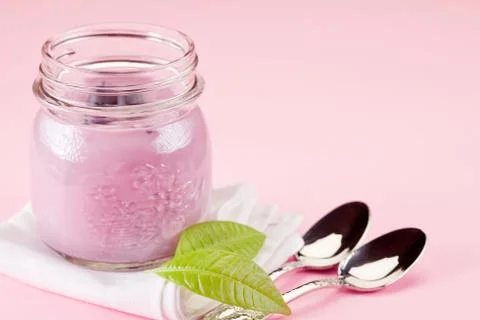 Yogurt on rose background Stock Photos