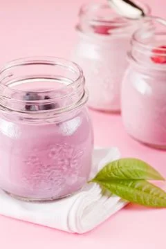 Yogurt on rose background Stock Photos