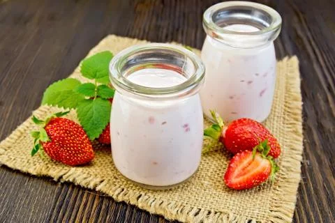 Yogurt with strawberries in jars on sacking Stock Photos