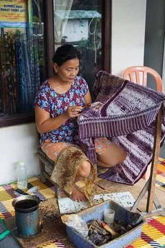 Yogyakarta, Java, Indonesia - March 6th 2018: Old woman painting Batik Stock Photos