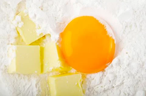 Yolk and butter on flour Stock Photos