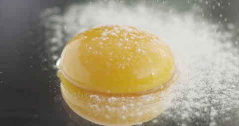 The yolk will be covered with flour on a mirror surface Stock Footage 198147094
