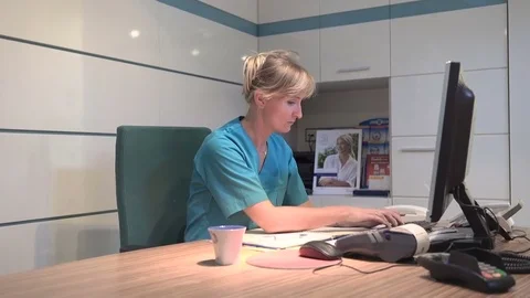 Yong receptionist typing on comuter has a headache. Steadicam shot. 库存影片 70306677