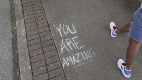 YOU ARE AMAZING Sidewalk Message with Pedestrians Passing By Stock Footage 159366299