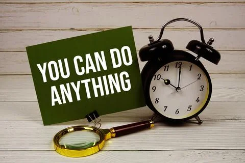 You Can Do Anything text message on paper card with alarm clcok and magnify.. Fotos de archivo