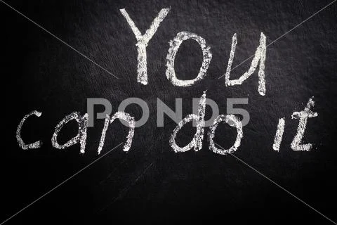 You can do it. Motivational inscription in chalk on a black background. Stock Photos