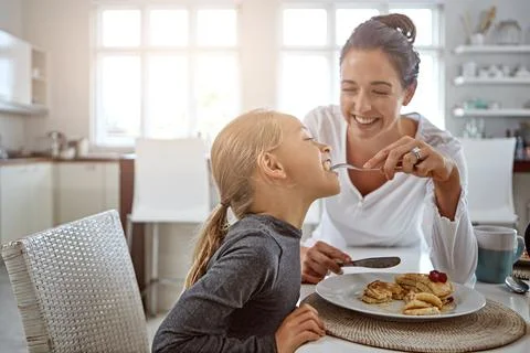 You can never go wrong with pancakes. a mother and daughter having breakfast at Stock Photos