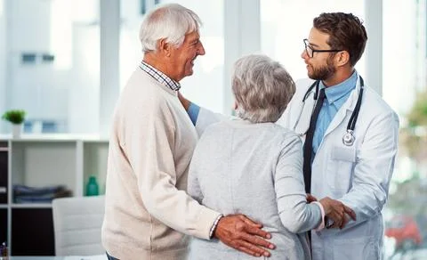 You have my assurance that all will be fine. a doctor comforting a senior couple Stock Photos