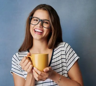 You just cant be grumpy with coffee in your hand. Studio shot of an attractive Stock Photos