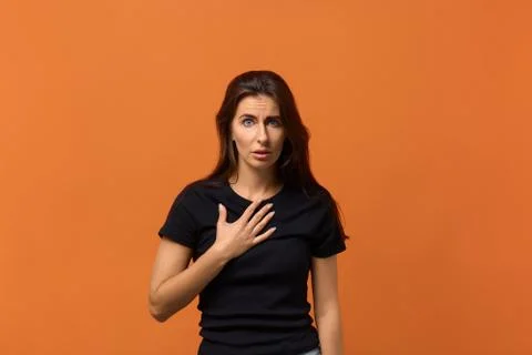 You mean me. Perplexed indignant caucasian woman in black t-shirt pointing at Stock Photos