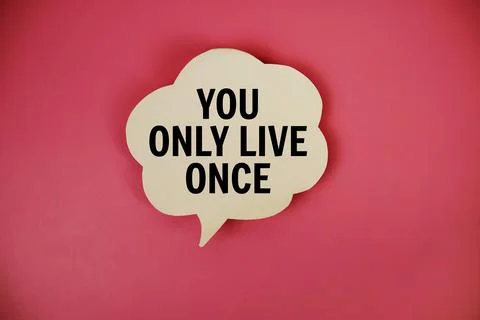 You Only Live Once text with speech bubble top view on pink background Stock Photos