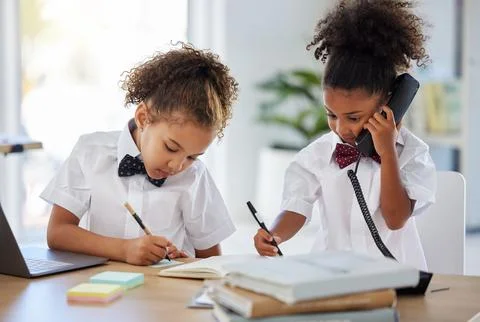 You talk, Ill write. two adorable little girls dressed as businesspeople sitting Photos