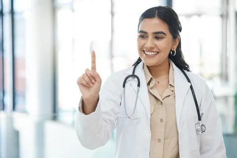 You treat a person, I guarantee you, youll win. a young female doctor holding up Stock Photos