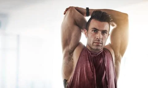 You will pull a muscle if you dont stretch. a handsome young man stretching at Stock Photos