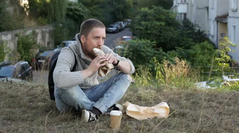 Youg man snacking outdoors Stock Footage 67613901