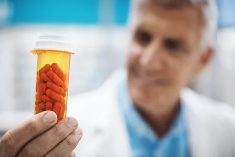 Youll never go wrong with this option. a pharmacist holding up capsules. Stock Photos