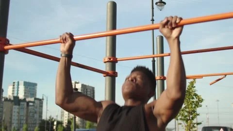 Youmg african man doing pull ups on horizontal workout outdoors Stock-Footage 143506560