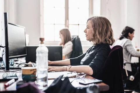 Yound devoted female software developers team working on desktop computer ... Stock Photos