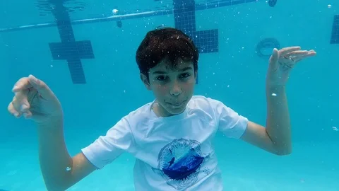 Young 12 year old boy gives thumbs up underwater Stockbeeldmateriaal 109552699
