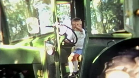 Young 3 year old boy pretending to drive a big tractor. Stock Footage 194569165