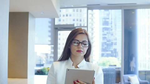 Young 30s girl with glasses using i-pad in big office Stock Footage 101079743
