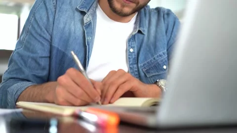 Young 30s man reading paper documents, analyzing project results in modern home Stock Footage 155332208