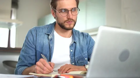Young 30s man reading paper documents, analyzing project results in modern home Stock Footage 155332211