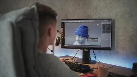 Young 3D designer creates and draws clothes using PC Stock Photos