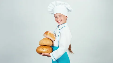 Young 7-8 years old baker holds three loaves of bread and looking at camera Video stock 67656438