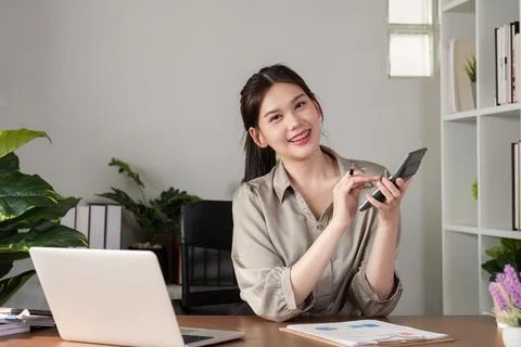 Young Accountant Using Telephone While Doing Paperwork in Modern Office Setting Stock Photos