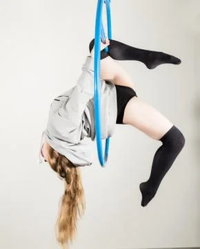 Young acrobat performs the acrobatic elements in the air. Aerial acrobat on a Photos