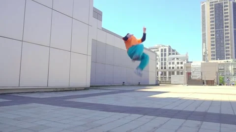 Young acrobatic guy jumping back somersault and dancing break dance outdoors Stock Footage 293839911