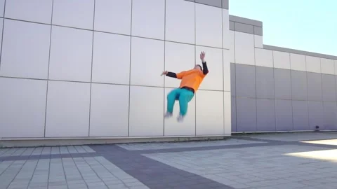 Young acrobatic guy jumping back somersault and dancing break dance outdoors Stock Footage 293839945