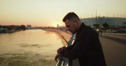 Young active athlete using smartwatch after workout in the city at sunset Stock Footage 276545889