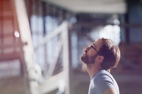 Young active beautiful bearded working american man in eyeglasses looking up  Stock Photos
