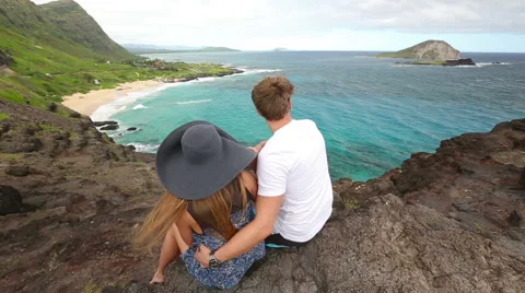 Young active couple sitting and looking at view in Makapuu Lookout, Oahu, Hawaii Stock Footage 58145830